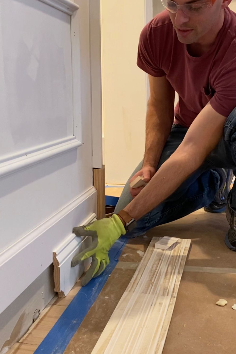 Contractor installing detailed baseboard molding in a custom interior, demonstrating precision craftsmanship during a renovation